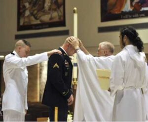 Ensign Anthony Lezcano, USN, a co-sponsored seminarian, places his hand on the shoulder of Bradley Lewis who is being received into full communion with the Catholic Church at St. Charles Borromeo Catholic Church in Tacoma, WA at the Easter Vigil Mass on 7 Apr 12.