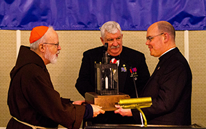 Sean Cardinal O’Malley, Archbishop of Boston, and Massachusetts Knights of Columbus State Deputy Russell A. Steinbach present the 2016 Lantern Award to Msgr. John J.M. Foster, Vicar General and Moderator of the Curia of the Archdiocese for the Military Services, USA, accepting on behalf of Catholic U.S. Military chaplains, in Framingham, Mass., on April 18, 2016. Photo Courtesy Luke Corcoran.