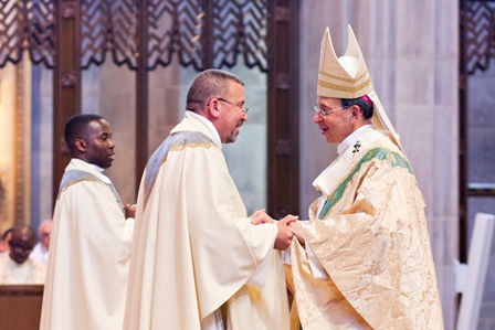 Bishop William Lori (right) welcomes Father Angel Marrero to the priesthood during ordination Mass June 8, 2013 in Baltimore. Photo Courtesy Tom McCarthy, Jr., The Catholic Review. 